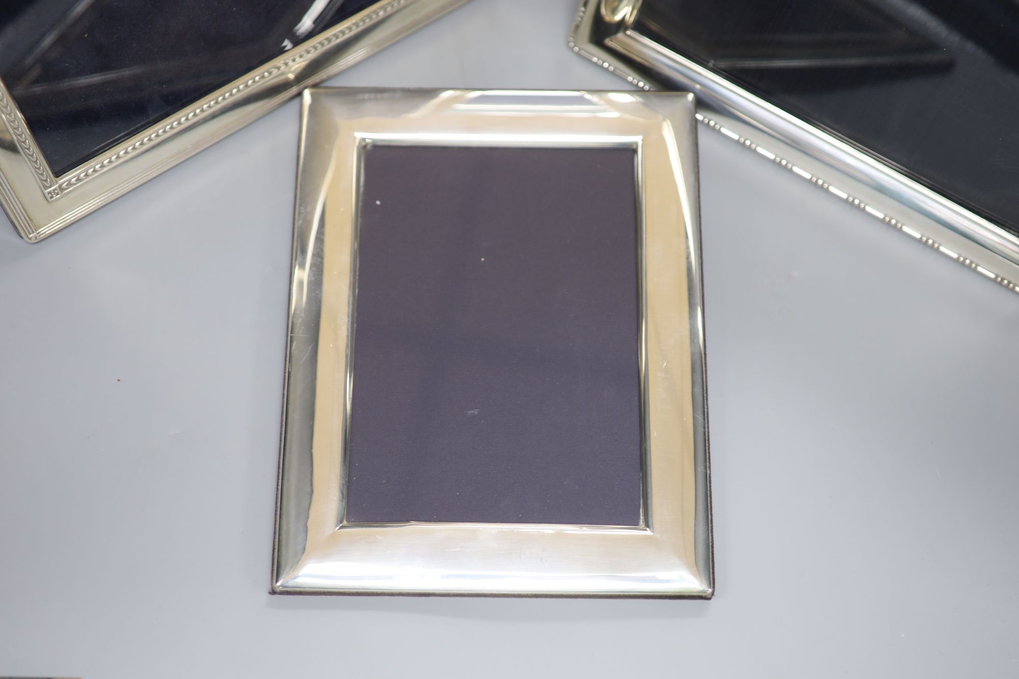 Four modern silver easel photographs frames, two with decorative banding